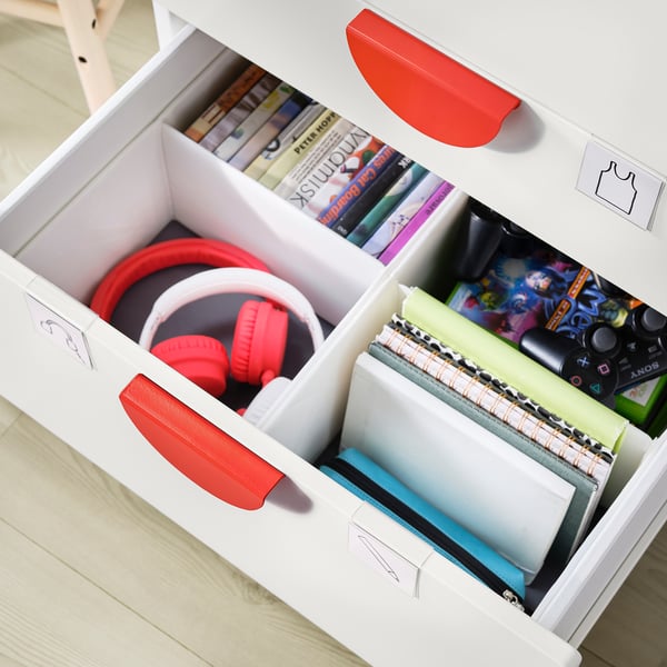 A white SMÅSTAD loft bed with red handles holding headphones and gaming accessories.