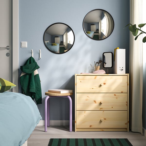 Small double white metal hook on wall, ideal for hallways or kitchens, holding green towel and coat.