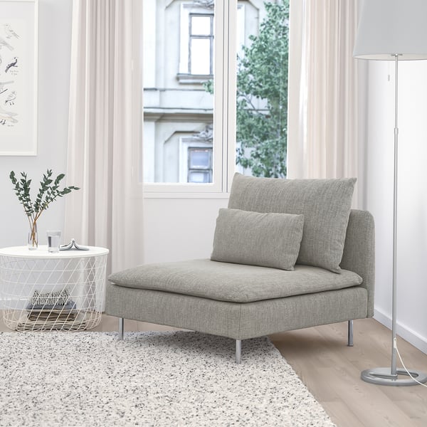 SÖDERHAMN grey chair, low & soft with elite textile. Small side table, floor lamp, & art nearby. Large window shows a building.