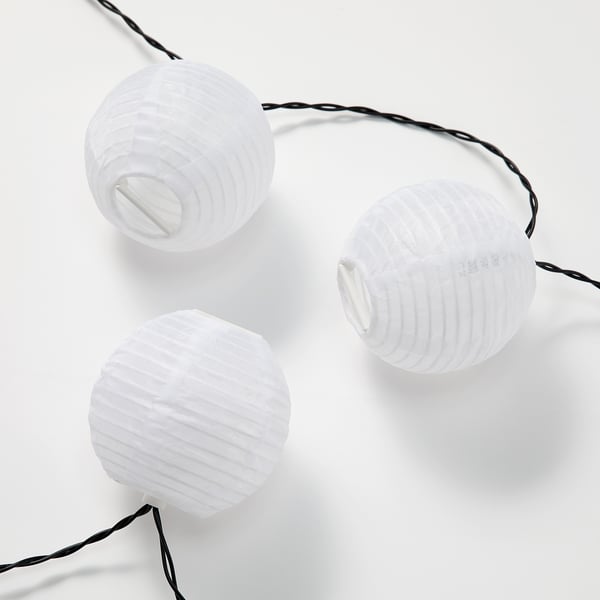 Three white lanterns hang in line, creating soft ambiance.