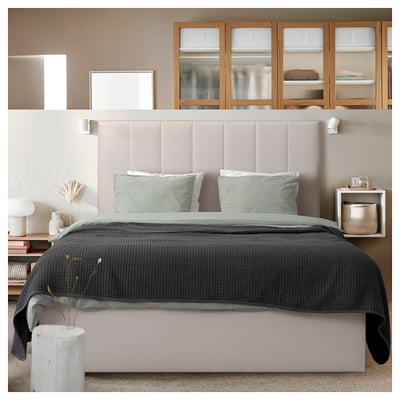 Cosy modern bedroom with TJÅLLE headboard in beige, stunt fabric, rectangle shape, soft padded design, matching bedding, wooden cabinets, walls.