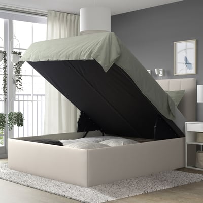 Modern TJÅLLE bed with light grey upholstery and black storage, near window.