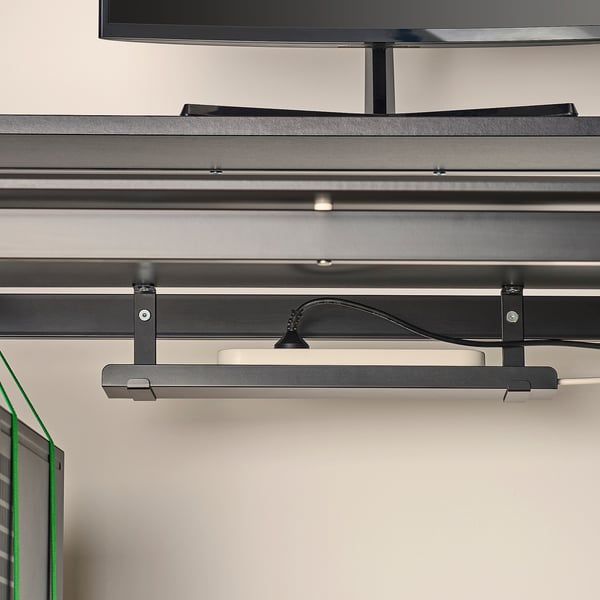 Modern gaming desk with adjustable height, cable management tray, and monitor stand.