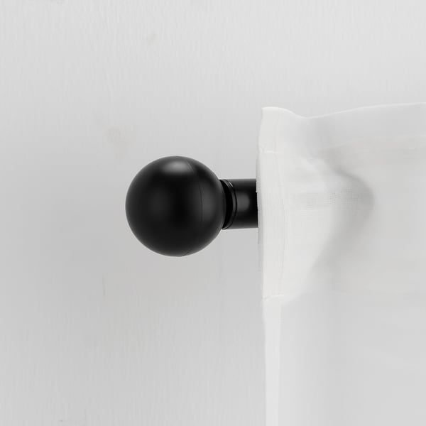 A VÄSENTLIG black globe finial on a curtain rod. Sleek, matte finish, recycled plastic. Small, yet noticeable, adds modern style.