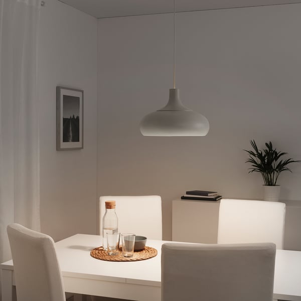 Modern dining area with grey VÄXJÖ pendant lamp, white chairs, and a clean, minimalist design.