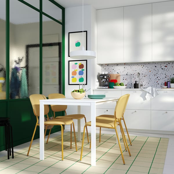 Modern kitchen with white VIHALS dining set: rectangular table and yellow chairs. Minimalist, green-tiled floor, white countertop.