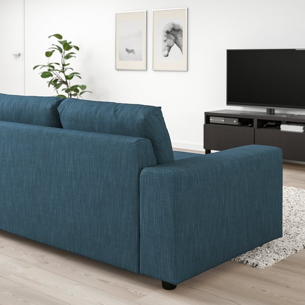 Modern blue VIMLE sofa in living room, matching tv stand, art, and plant.
