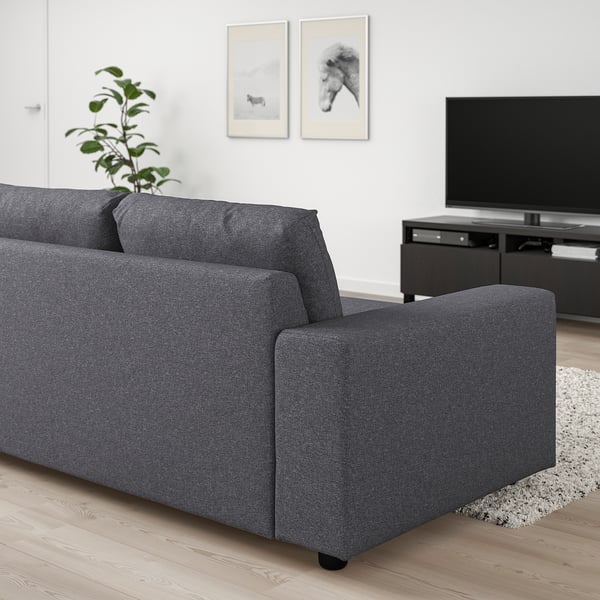 Modern living room with VIMLE dark grey sofa-bed, flat screen tv, and plant. Sofa large and plush.