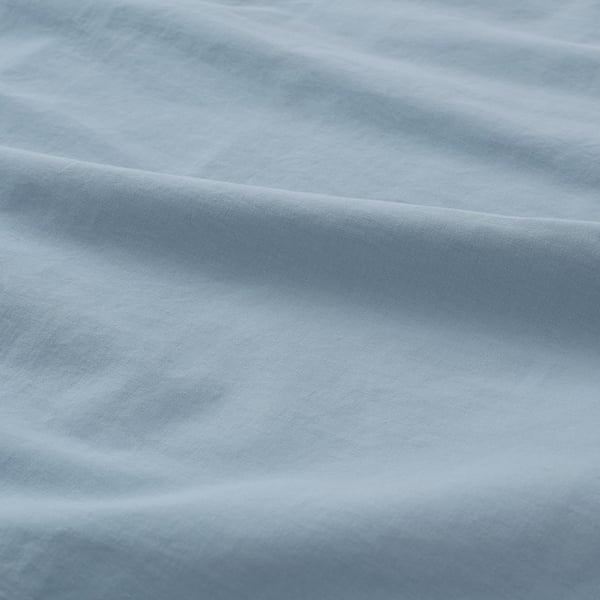 Close-up of soft, textured light blue pillowcase showcasing fine weave and smooth fabric.