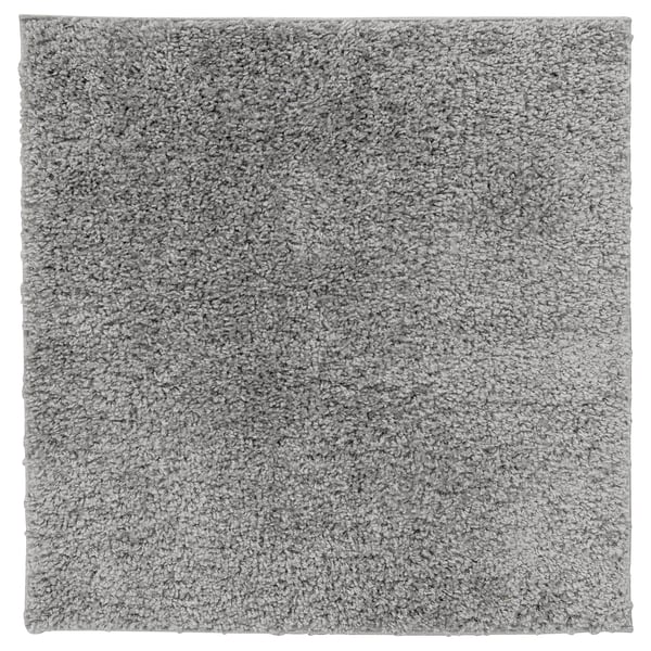 A square grey ÄRENDE rug with a shaggy texture, made of polypropylene and synthetic rubber, ideal for comfort and sound absorption.