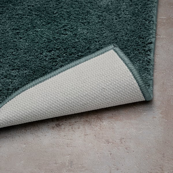 Green bath mat with white backing, non-slip surface.