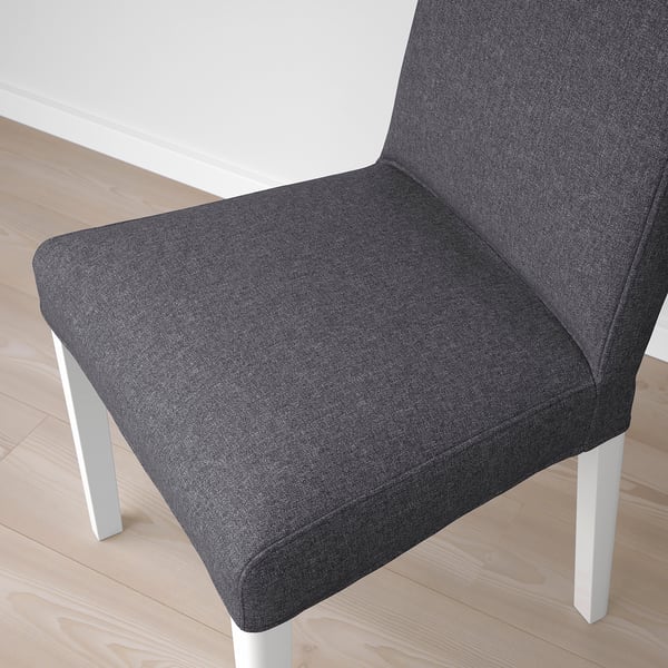 Modern grey upholstered chair with clean lines and padding on wooden floor.