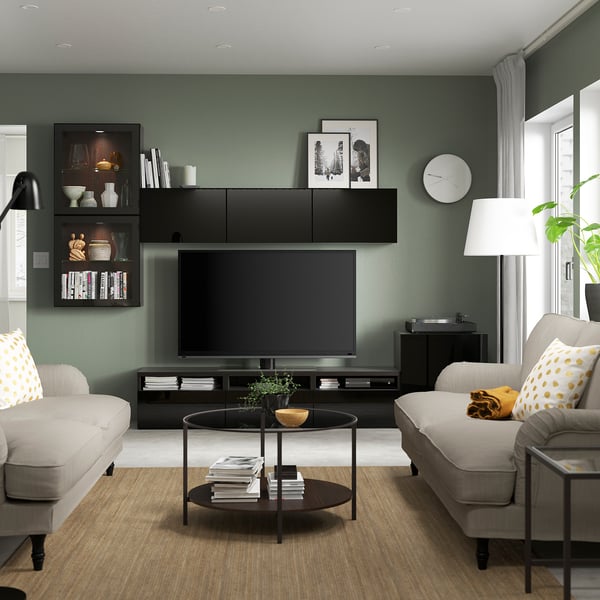 Modern living room with large black BESTÅ tv stand, taupe sofas, and sleek decor.