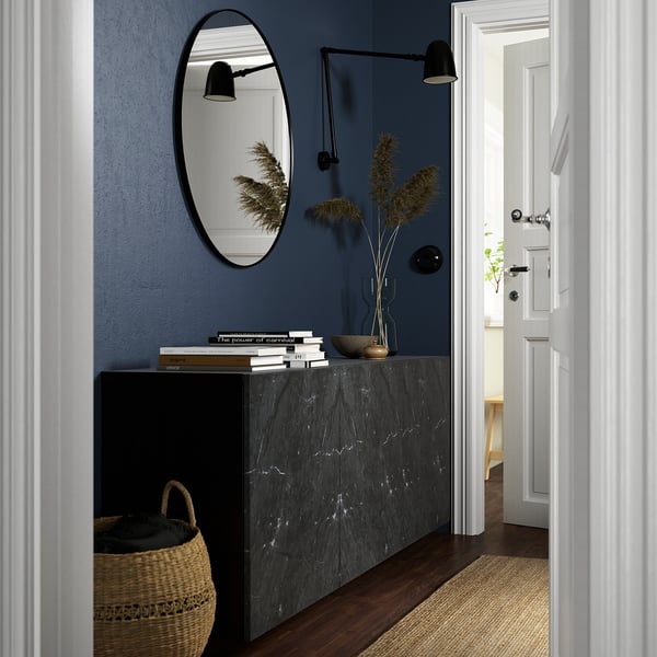 Modern hallway BESTÅ storage cabinet with sleek marble surface, circular mirror, and wall lamps. Basket below offers extra storage.