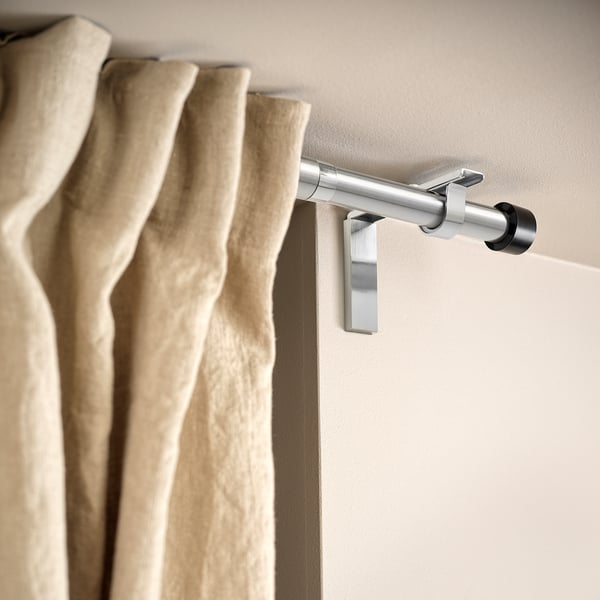 BETYDLIG curtain rod holder on wall, adjusts position, supports beige curtains