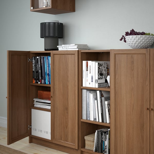 Wooden bookcase with open door displaying books and items. Modern design, suitable for home storage and organisation.