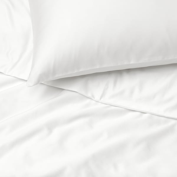 Crisp white bed sheets, likely made of high-quality cotton, neatly arranged; showcasing smooth, sateen finish.