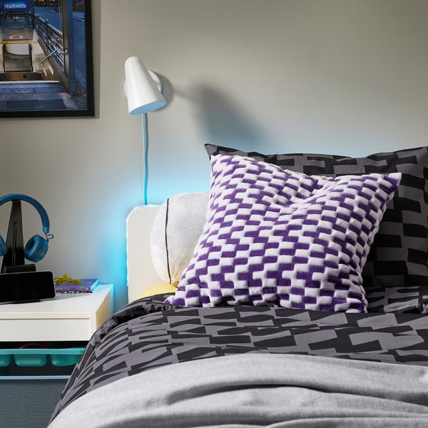Bedroom with chair, cushion, side table, framed picture, lamp