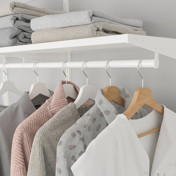 Closet with white BOAXEL rail. Hangs clothes on hangers, underneath stack of folded blankets on white shelf.