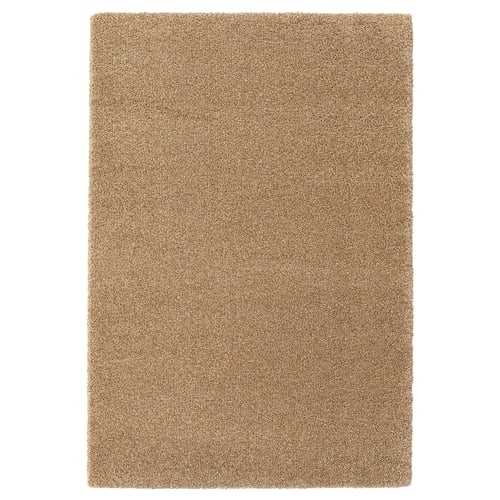 A beige BREVBÄRARE rug with a plush, uniform texture, rectangular shape, and solid design, made from polypropylene and synthetic rubber.