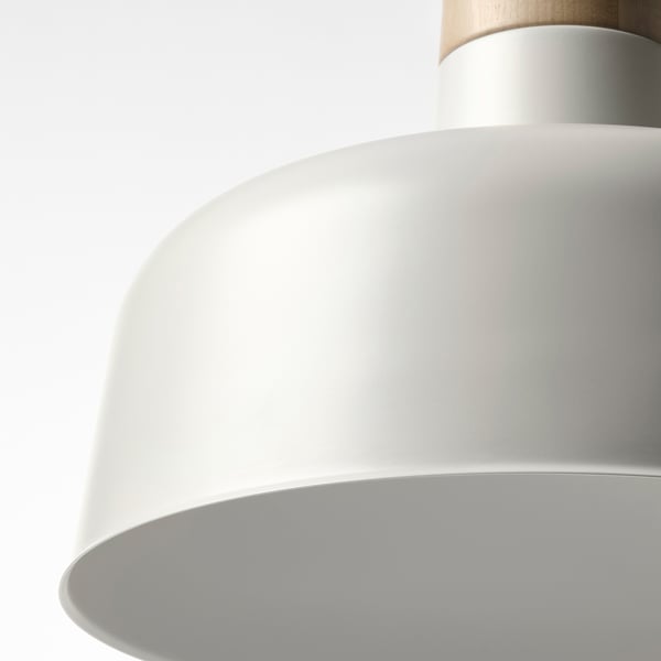 Close-up of a sleek, modern pendant lamp with a smooth, white metal shade and a natural wooden accent at the top.