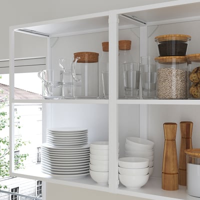 Modern kitchen shelves display clear jars, plates, bowls, and wooden containers, showcasing kitchen essentials.
