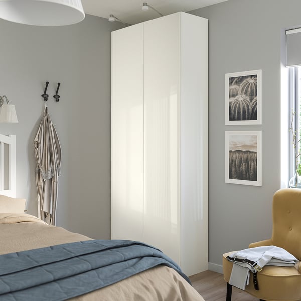 A modern bedroom with a tall, sleek FARDAL wardrobe in white gloss finish, larger than the nearby yellow chair, against a grey wall.