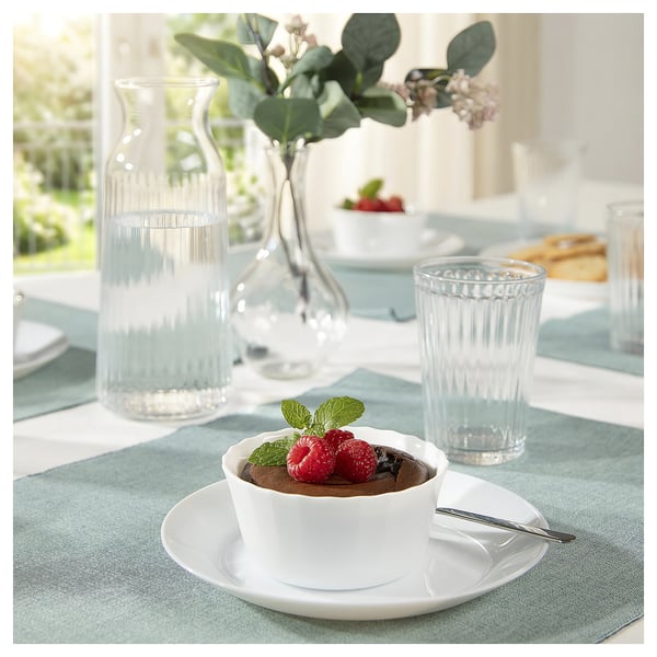 Displays a FISKTÄRNA white glass serving dish with raspberries and mint on a blue-gray tablecloth.