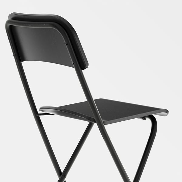 Black folding stool with metal frame and wooden seat. Sturdy design, easy to fold.