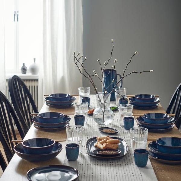 GLADELIG blue ceramic dinnerware set. Includes bowls, plates, cups, and vase. Modern design, varied sizes, craftsmanship details.