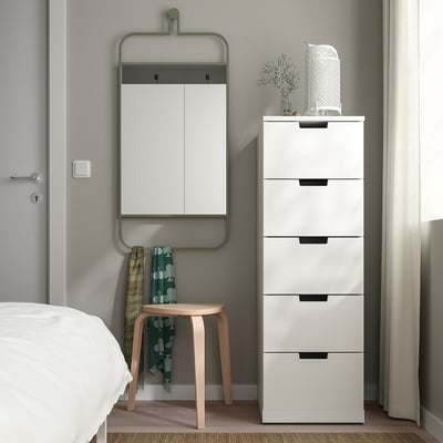 Wall mirror GRANVÅG with green frame reflects room, above white cabinet.