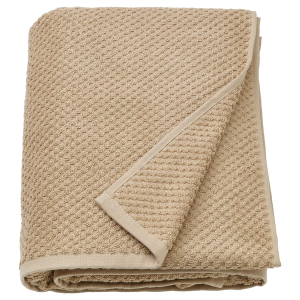 Folded beige cotton towel, soft, textured, rectangular.