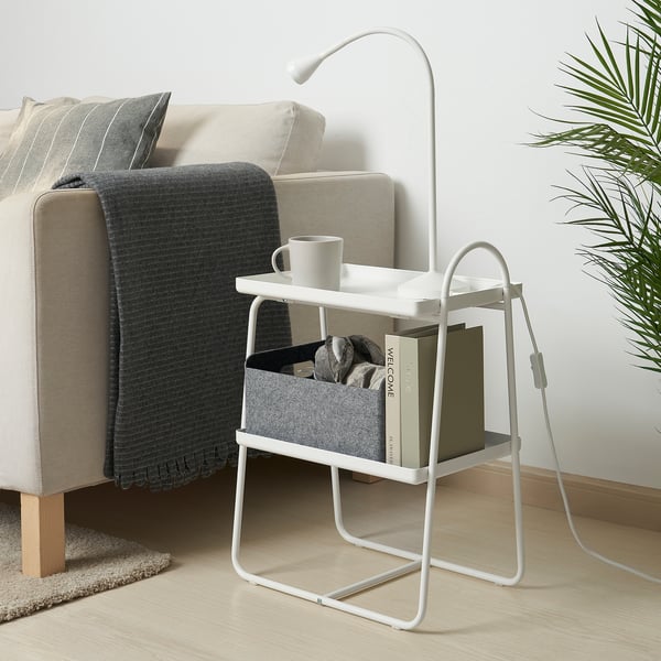 Cosy living room setup with a white HATTÅSEN side table, holding a mug, books, and a lamp next to a beige sofa.