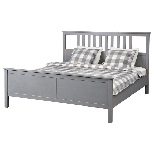 Grey HEMNES wooden bed with chequered bedding, rectangular shape, clean minimalist design.