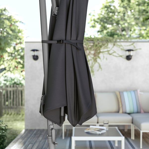 The HISSÖ parasol, black, open on patio, aluminium pole, polyester fabric, rectangular canopy, with tilting feature.