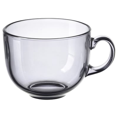 Single, transparent grey glass cup with small handle, round shape.
