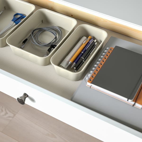 Organised desk drawer with cable management, pens, and notebook.