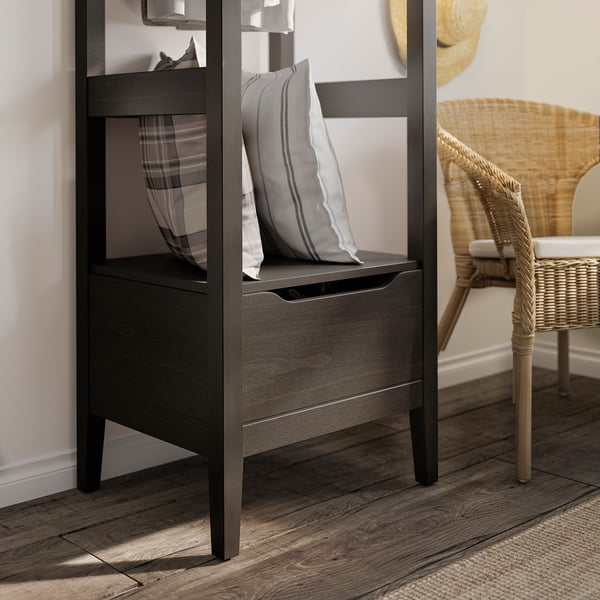 Modern black IDANÄS storage bench with striped cushion in cosy room.
