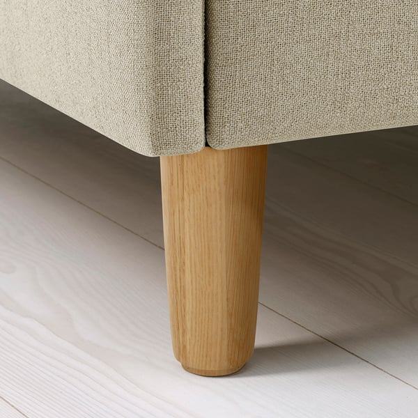 Crafted bed leg close-up, sturdy light wood supports plush upholstered frame on sleek floor.