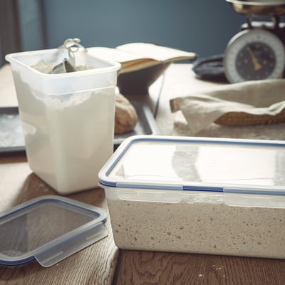 Plastic containers on wood, holding powder and grey substance.
