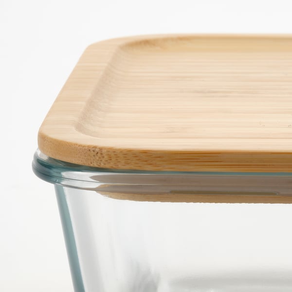 Close-up of a clear glass food container with a fitted bamboo lid, showing its quality and design.