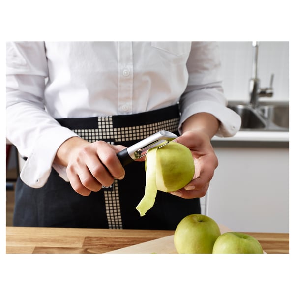 Person peeling apple with IKEA 365+ VÄRDEFULL peeler in kitchen.