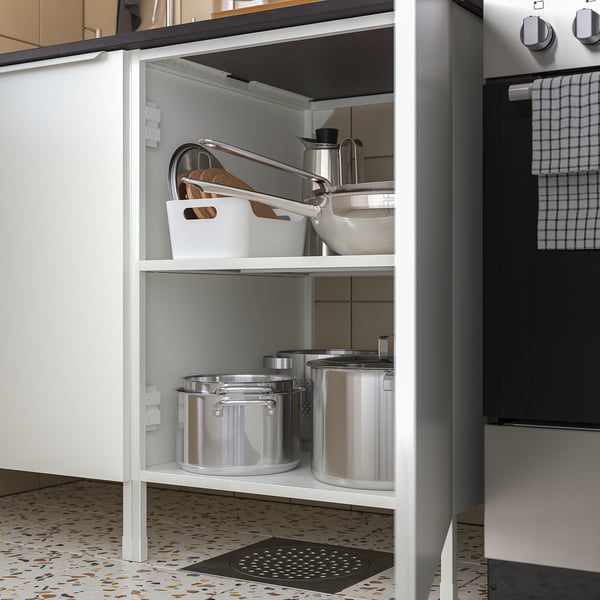 Open kitchen cabinet showing containers, bowls, and utensils organised on shelves.