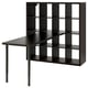 KALLAX dark brown cube shelving unit with attached angled desk, combining storage and workspace efficiently.