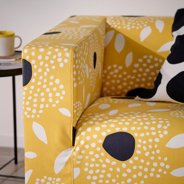 Bright yellow sofa with white & black polka dot and leaf pattern, stylish and comfortable, ideal for cosy rooms.