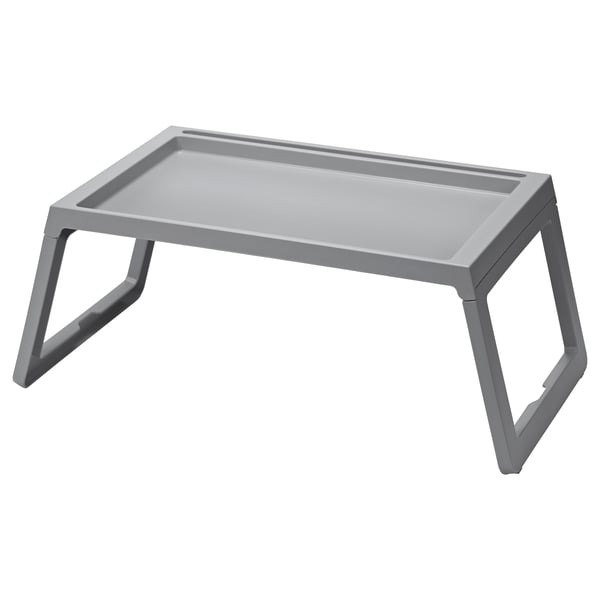 A grey KLIPSK foldable bed tray with v-shaped legs made of polypropylene plastic. It has a flat rectangular top with a groove for holding a tablet.