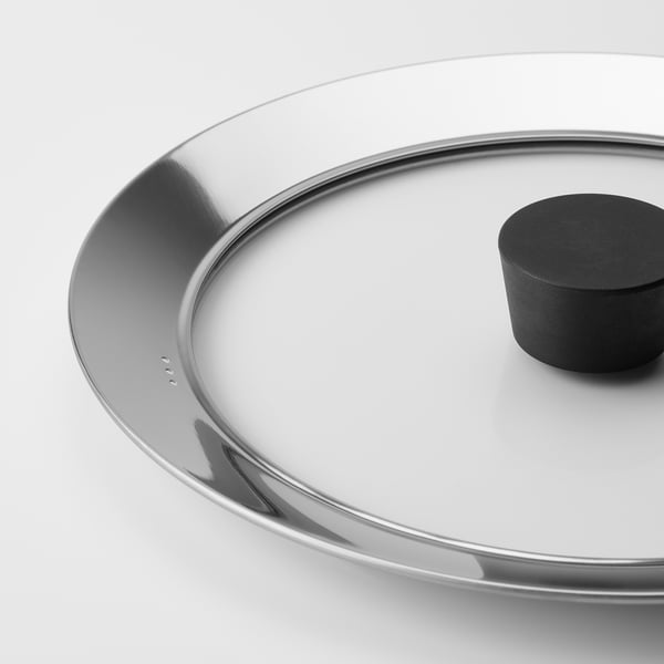 Close-up of clear glass lid with metal rim, showcasing quality design and materials.