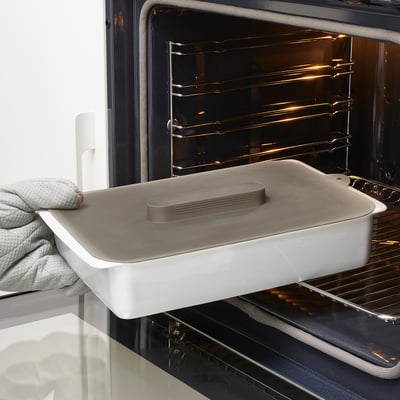 Oven dish with silicone lid and vacuum seal to keep food fresh and prevent splatters.
