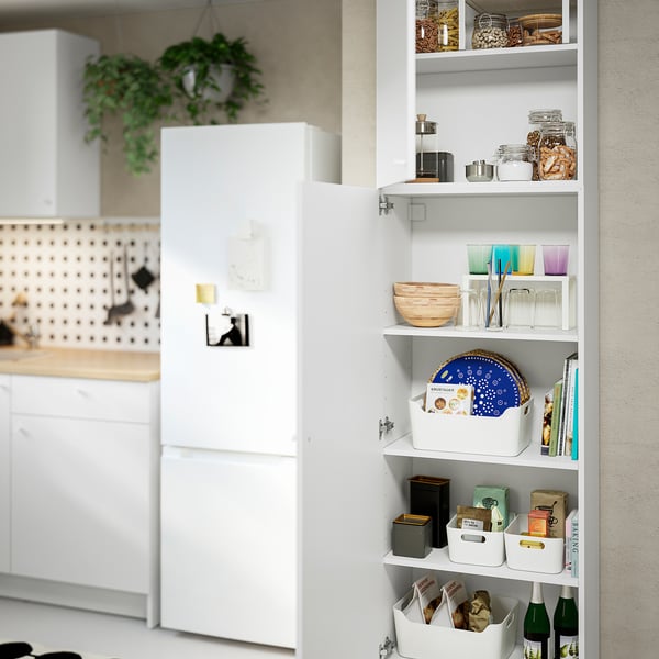 Well-organized kitchen cabinet with various items stored. Includes jars, glasses, bowls, and boxes, maximising storage and accessibility.