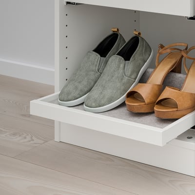 White pull-out shelf with grey trainers and tan sandals, part of IKEAs KOMPLEMENT storage system for organised wardrobe access.